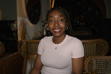 Portrait of a young black woman smiling in a restaurant