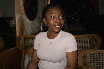 Portrait of a young black woman smiling in a restaurant