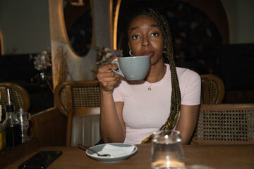 A young woman drinking coffee in a bar