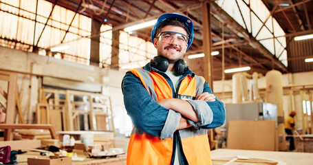 Fototapeta premium Carpentry, crossed arms and portrait of man in factory for furniture repair, restoration and woodworking. Carpenter, safety gear and happy person in workshop for wood, lumber and timber production