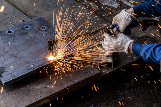 Industrial Worker Cutting Metal With Welding Sparks - Powered by Adobe