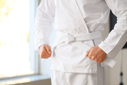 Young man practicing karate in dojo, closeup