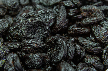 Raisins as a background image. Close-up of raisins, dark-colored dried grapes. Dark blue macro shot of seedless raisins
