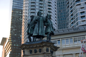 Obraz premium Close-up of Johannes Gutenberg memorial bronze staute at Rossmarkt at German city of Frankfurt on an autumn sunset. Photo taken November 22nd, 2025, Frankfurt am Main, Germany.