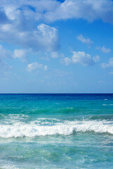 View of the blue Mediterranean sea with waves and blue sky with light clouds