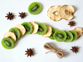 Dried kiwi slices and apple rings arranged with star anise and twine  