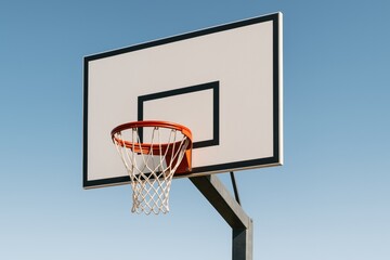 Minimalist basketball hoop and backboard under clear blue sky with strong natural light and clean background emphasizing outdoor sports concept. Ai generative