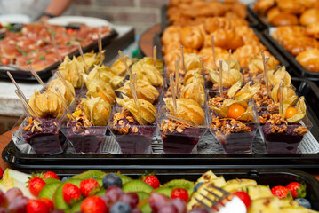 Dessert buffet with assorted sweets. An enticing array of desserts featuring various sweets such as berries, pastries, and physalis-topped treats.