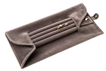 Grey velvet jewelry travel roll organizer with two rings displayed on a transparent background