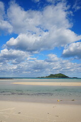 fine seascape with sand bar and island and clouds