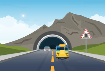 A car driving through a road tunnel with a road tunnel sign at the entrance.