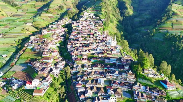 Drone shot capturing a beautiful highland community on the slope of Mount Sumbing, Central Java, with colorful houses, local architecture, and rich natural surroundings. Nepal Van Java.