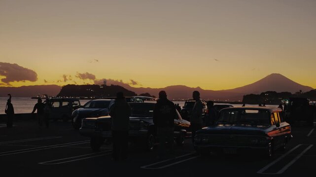 People watching mount fuji sunset in a classic car parking lot