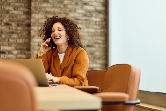 Bright Smiling Woman On Call At Modern Workspace With Laptop And Brick Wall Open Office - Powered by Adobe