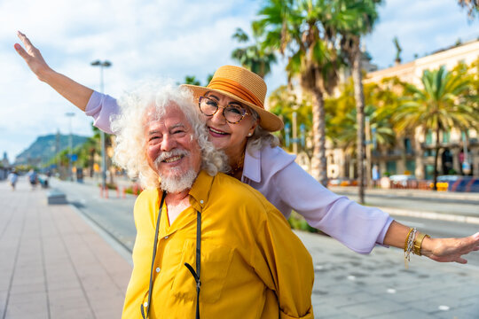 Senior couple enjoying piggyback ride during city travel