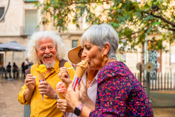 Senior friends enjoying ice cream and laughing outdoors