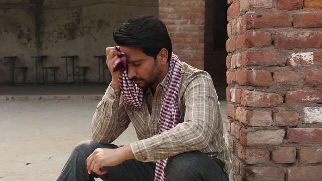 Young indian thoughtful sad man feeling alone. sadness, depression. Rural india. Unemployment