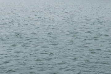 the surface of the water with ripples on an autumn day