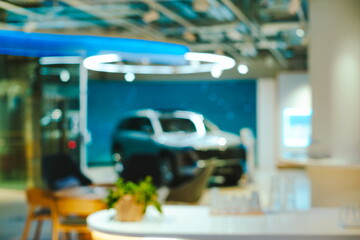 Blurry, light blue, defocused new car inside dealer showroom at night. Outside looking in shot, abstract background, no people