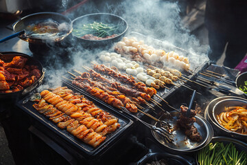 Captivating street food display featuring an array of grilled meats and simmering delicacies under