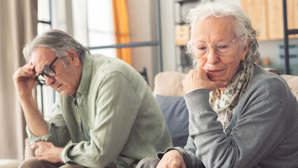 Mature couple sitting back to back not talking