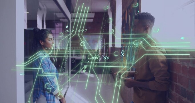 Discussing pair studying neon AR overlay in office hall, holding phone, blue plaid, brown sweater - Powered by Adobe