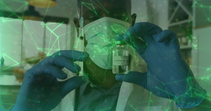 Presenting worker in lab coat, surgical mask and gloves holding syringe and COVID-19 vial at clinic - Powered by Adobe