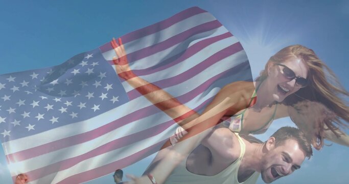 Couple doing piggyback on beach with US flag overlay, woman wearing bikini and sunglasses