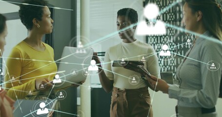 Discussing network overlay, four women in meeting holding tablet, docs, phone in work attire