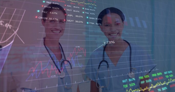 Standing nurses in scrubs viewing finance charts on glass panel in clinic, with tablet, stethoscope - Powered by Adobe