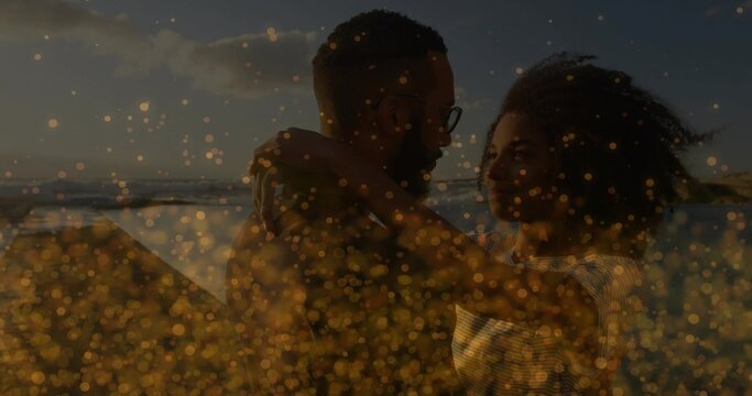 Embracing couple holding chest-to-chest at beach sunset, with glasses, striped top, golden bokeh