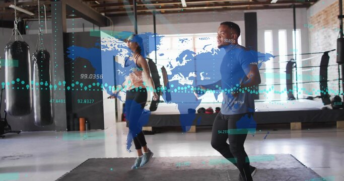 Skipping duo wearing gym gear jumping ropes on mats near heavy bags, with world map overlay - Powered by Adobe