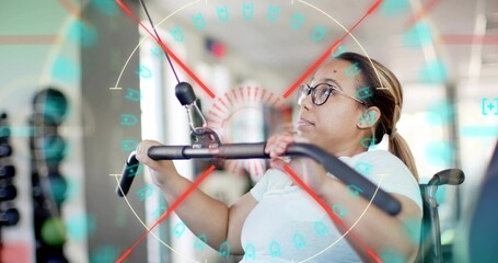 Pulling woman in wheelchair wearing glasses, light tee, gripping lat bar and cable at gym, HUD