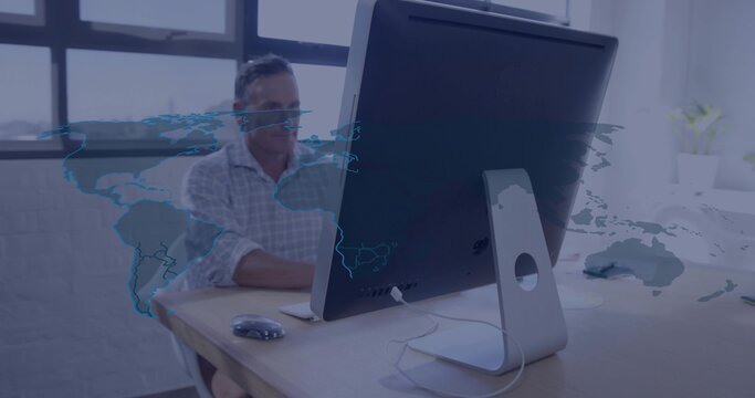 Working man in checked shirt, glasses typing at office desk with monitor, mouse, world map overlay - Powered by Adobe