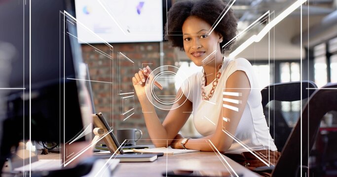 Writing woman wearing white sleeveless top at open office with monitor notepad pen and HUD overlays - Powered by Adobe