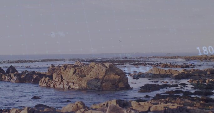 Showing large jagged rock rising from shallow surf at rocky coast, with digital overlay 180