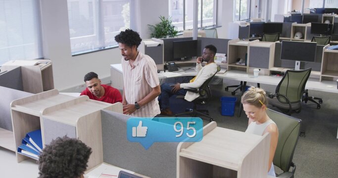 Talking standing man in short sleeves leaning at cubicle in open office, with social overlay 95