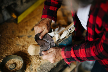 Craftsman shaping wood in a workshop with tools and sawdust