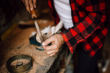Craftsman working on wood with tools in a workshop