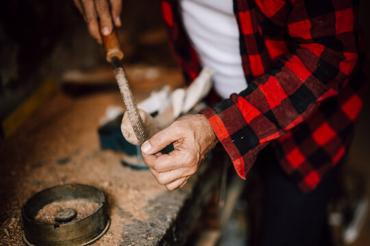 Craftsman working on wood with tools in a workshop