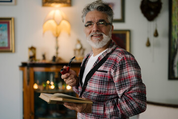 Senior man enjoying a quiet moment with a book and pipe
