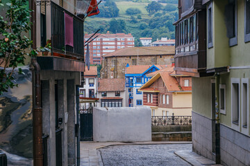 Narrow Cobblestone Street View of Traditional Buildings and Green Hills