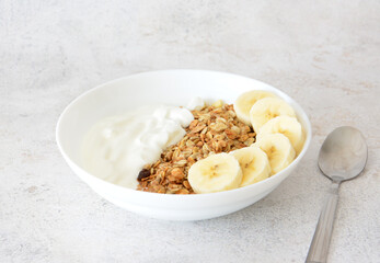 a close up of Healthy Breakfast Bowl with Yogurt, Granola and Banana slices