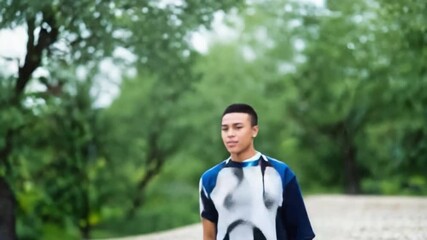 Thoughtful Stroll in the Park: A young person takes a leisurely walk amidst the lush greenery of a park, the serene environment mirroring his composed demeanor.