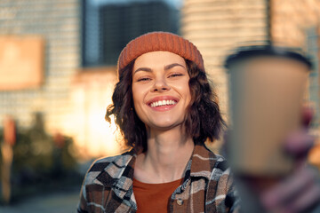 woman smile coffee urban portrait beanie candid authenticity in golden hour glow, relaxed city morning scene with mindful living vibe and emotional storytelling of sincere joy