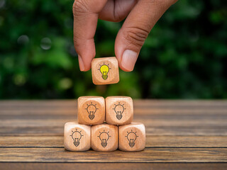 Creative idea, solution and innovation concept. Idea generation and screening for product development process. Wooden blocks with light bulb and yellow color icons on clean background and copy space