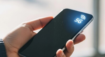 Person hand holding smartphone with with 5G icon on screen. Advanced mobile technology concept for fast internet and modern digital communication