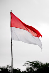 The Indonesian Red and White Flag Waving Against a Bright Overcast Sky