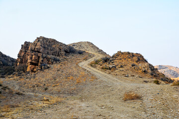 A canyon in the desert. Bare mountains and a canyon. Beautiful nature like on planet Mars. The rocky walls of the canyon are high. Mountain landscape