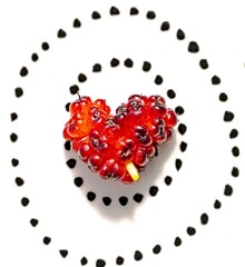 A heart shaped mulberry on a black and white background.